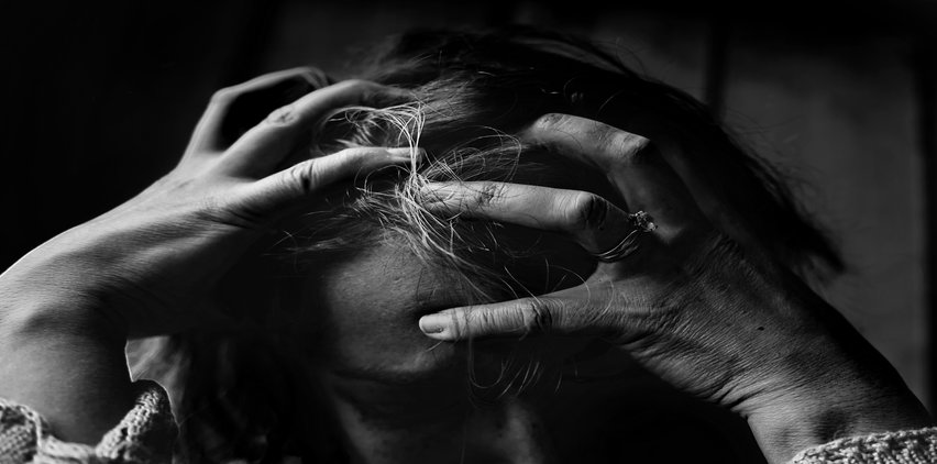 woman holding head in hands from stress