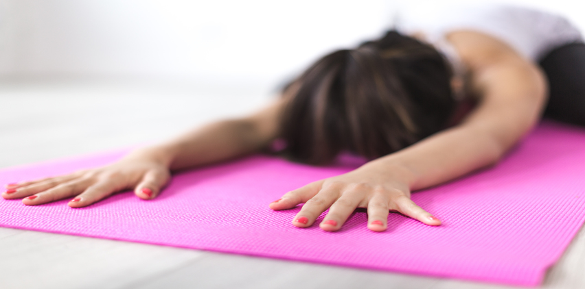 woman doing yoga on mat for holiday stress