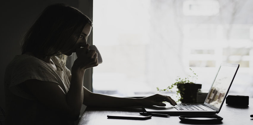 woman drinking coffee freelance writing laptop