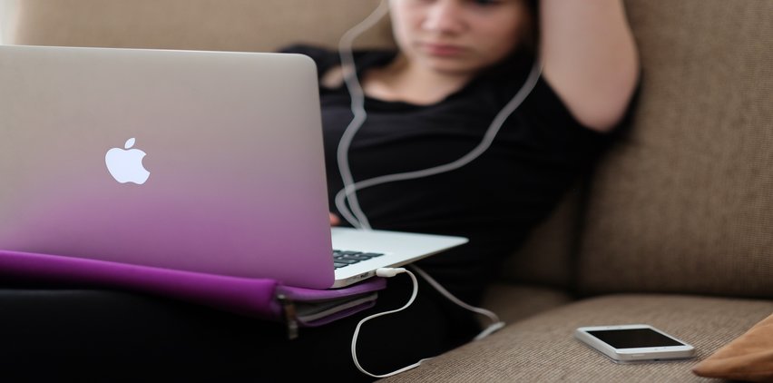 woman using headphones learning freelance skills on computer