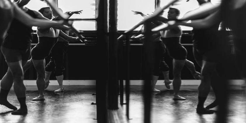 unsplash. Women dancing in front of mirror in black and white