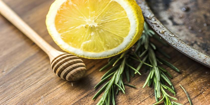 Unsplash. closeup of lemon and rosemary on a wooden table.