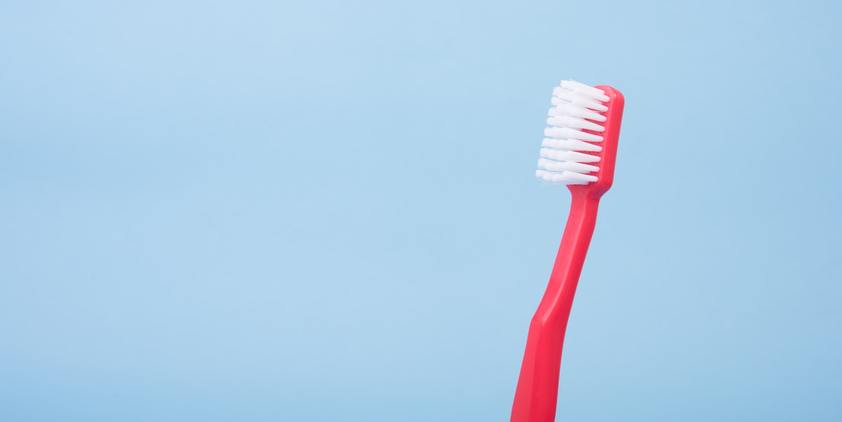 Unsplash Red toothbrush on blue background