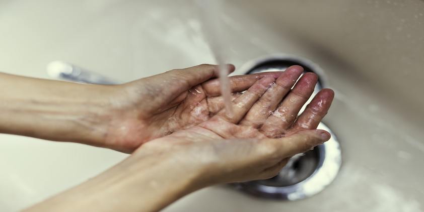 Unsplash. Person washing hands over sink