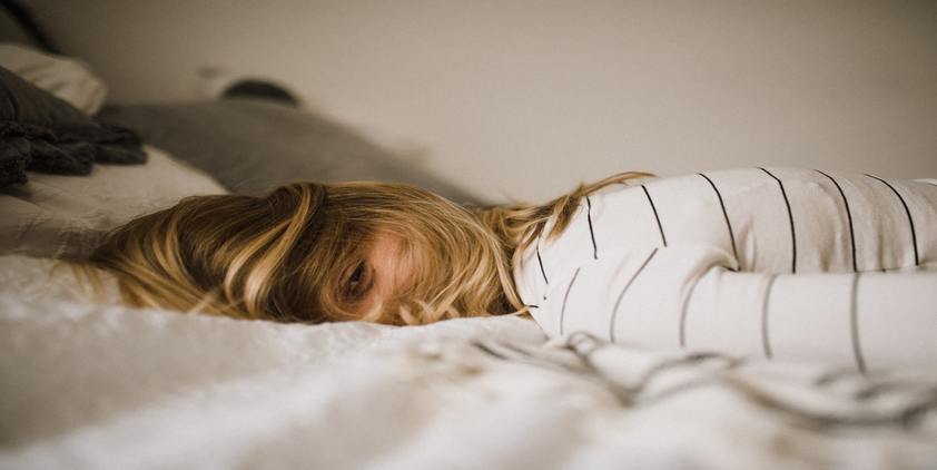 unsplash. blonde woman in white wearing white striped t shirt laying on bed