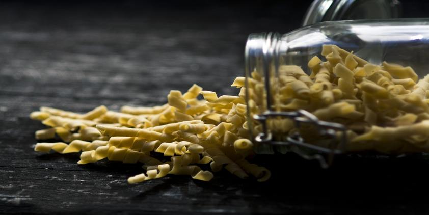 unsplash. closeup of spiral pasta spilling out of jar