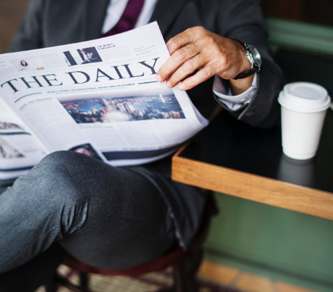 man sitting and reading newspaper