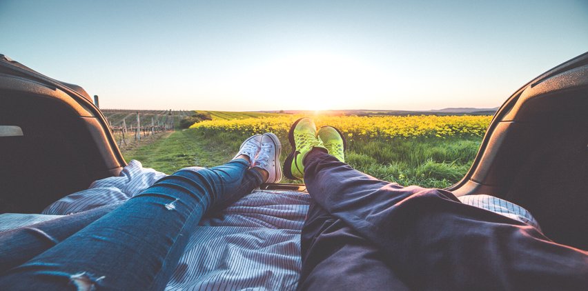 couple relaxing in back of a truck viewing flowers