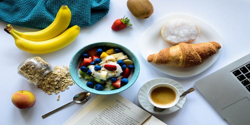 Unsplash. breakfast spread with fruit, oatmeal, coffee, and croissant