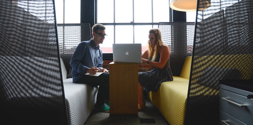 A woman and man looking at a laptop together