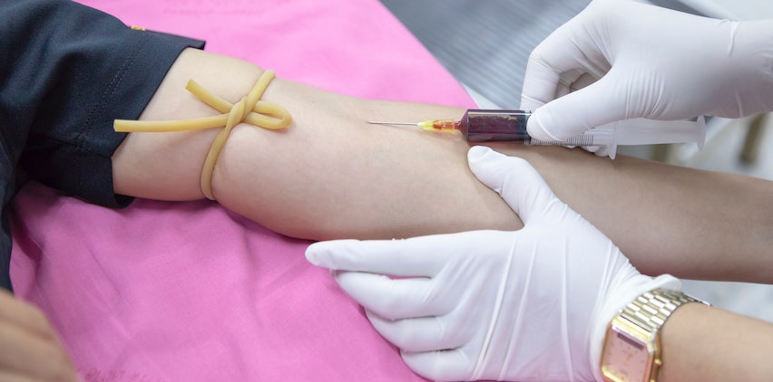 A woman gets her blood drawn for health screenings at a doctor's visit.