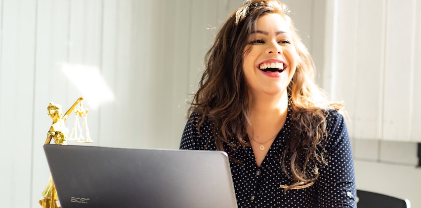 Woman smiling in front of laptop