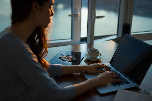 woman typing on laptop writing SEO friendly blog posts