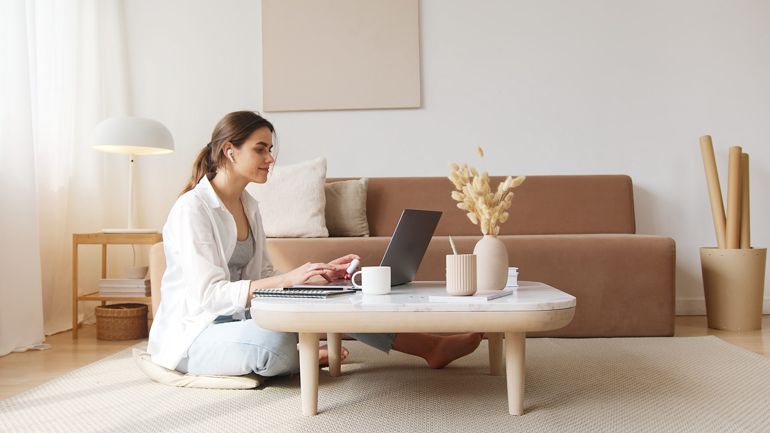 A woman working on her laptop on a coffee table