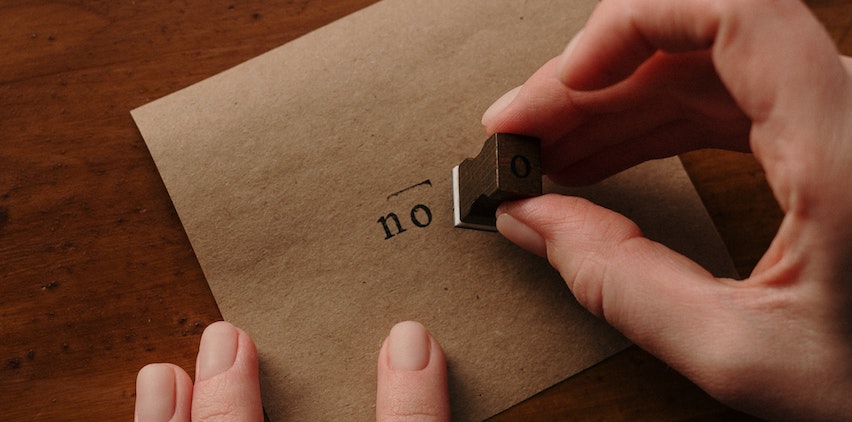 A person stamping the word no on an envelope