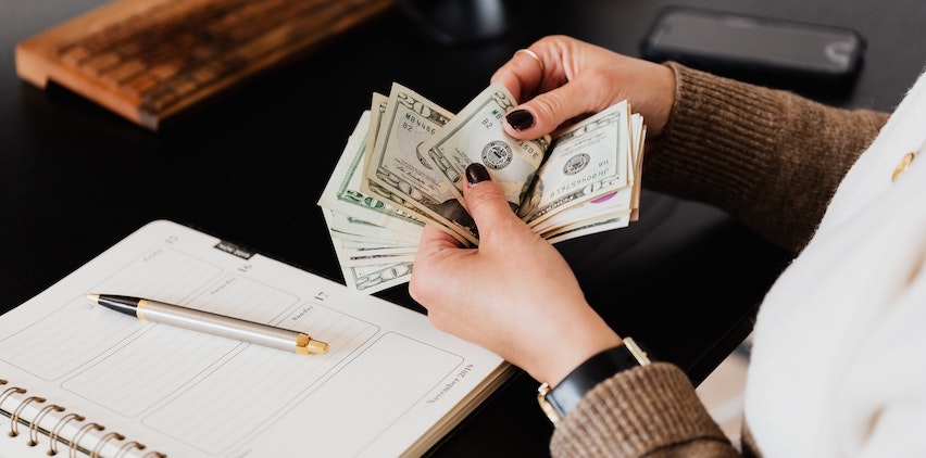 Woman counting cash at her desk