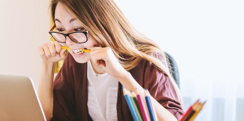 A woman looking nervous at a computer