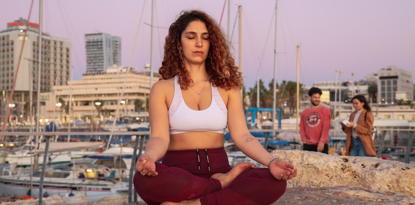 Woman practicing meditation in a marina