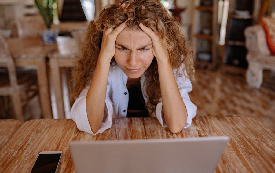A frustrated woman looking at her computer