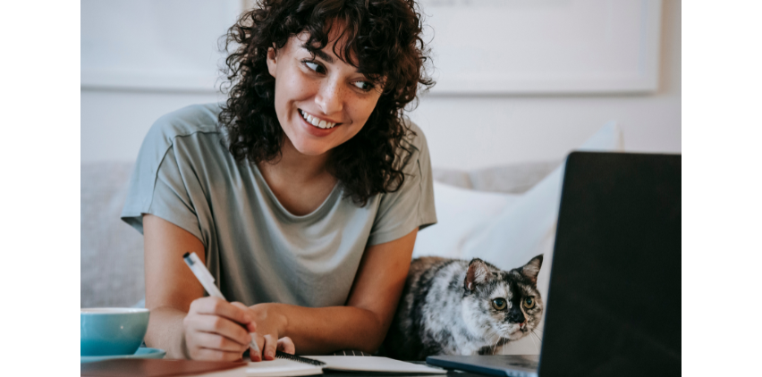 woman reading affirmations and writing in notebook